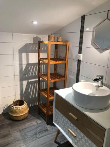 La salle de bains est pourvue d'un lavabo et d'une étagère en bois. dans l'établissement Villa dans le Périgord, à Couze-et-Saint-Front