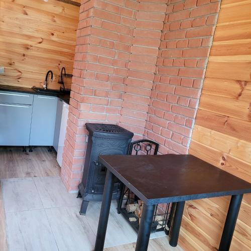 a kitchen with a table and a brick wall at Domek dla dwojga in Pelnik