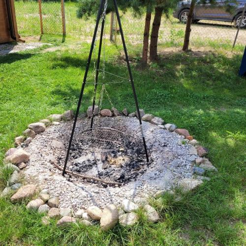 a fire pit in the grass in a yard at Domek dla dwojga in Pelnik