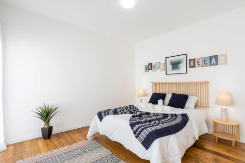 a white bedroom with a bed and a rug at Stylish 3-Bedroom Villa Haven with a Private Pool in Albufeira