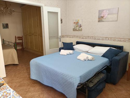 a blue bed with two towels on top of it at Casa di Lia in Montelepre