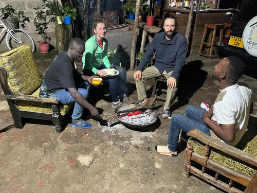 a group of men sitting around a camp fire at Meleji Studio House in Arusha