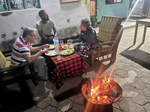 a group of people sitting around a table with a fire at Meleji Studio House in Arusha