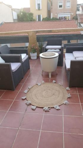 une grande baignoire assise sur une terrasse avec des chaises dans l'établissement La maison Provençale avec Piscine, à Marseille