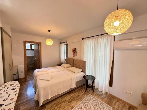 a bedroom with two beds and a table and two lights at Villa Merry - Dalyan Stonehouse with Palmtrees, 50m to River in Ortaca