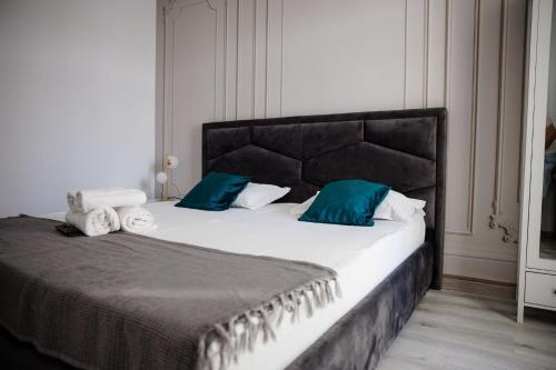a bedroom with a large bed with blue pillows at Complex Omnia - Apartamente Husi in Huşi