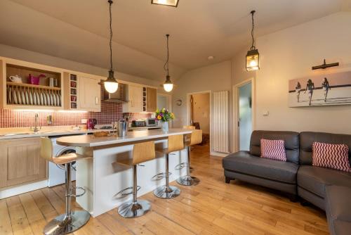 a kitchen and living room with a bar and a couch at Tor Farm Lodges - Private Hot Tubs, Shared Seasonal Outdoor Pool, Dog Friendly in Cheddar