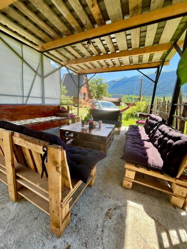 a gazebo with couches and a table and chairs at Lela Guest House in Mestia