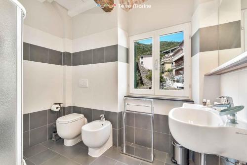 a bathroom with a toilet and a sink and a window at Lover's Lane 2, TerreMarine in Riomaggiore