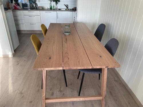 a wooden table with chairs around it in a kitchen at super uitzicht in Kjerringøy