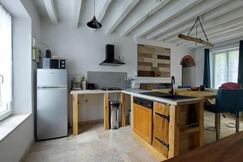 a kitchen with a white refrigerator and a table at Maison de campagne proche des Châteaux et Beauval in Selles-sur-Cher