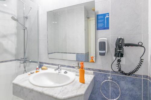 a bathroom with a sink and a phone on the wall at Beachfront Apartment Playa del Cura 3 by VillaGranCanaria in Playa del Cura