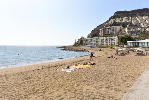 a group of people laying on the beach at Beachfront Apartment Playa del Cura 3 by VillaGranCanaria in Playa del Cura