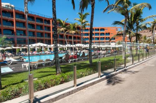 a resort with a pool and palm trees and a hotel at Beachfront Apartment Playa del Cura 3 by VillaGranCanaria in Playa del Cura