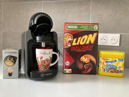 d'une cafetière et d'une boîte de lions de céréales cruches fragiles et d'un café dans l'établissement Appartement 87 m2 - 3 chambres - 6 personnes - Proche Paris - Parking gratuit, à Asnières-sur-Seine