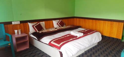 a bedroom with a large bed with a wooden headboard at Full Moon Cottages Pangong Ladakh by LexStays in Kakstet