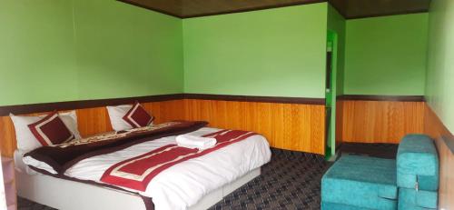 a bedroom with a large bed and a blue chair at Full Moon Cottages Pangong Ladakh by LexStays in Kakstet