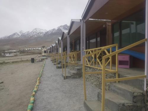 a row of houses with mountains in the background at Full Moon Cottages Pangong Ladakh by LexStays in Kakstet