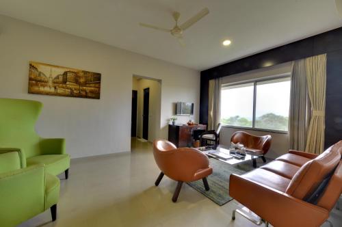 a living room with a couch and chairs at The Fern Residency, Vadgaon - Talegaon, Pune in Pune