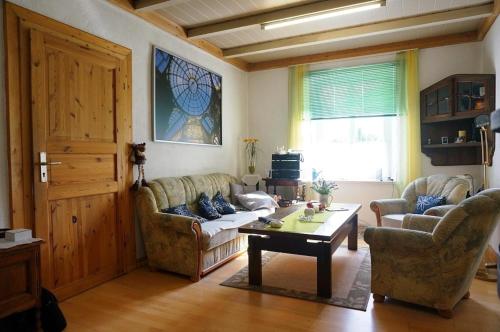 a living room with two couches and a table at Wohnen im Gutshaus in Lalendorf