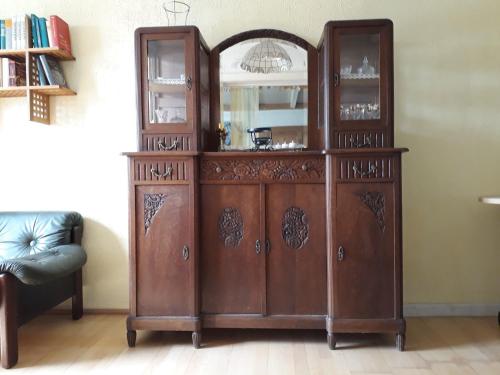 a wooden cabinet with a mirror in a room at Wohnen im Gutshaus in Lalendorf