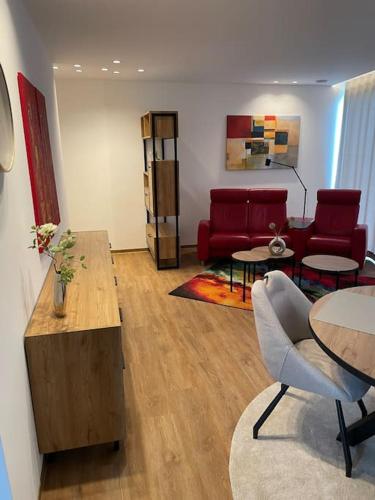 a living room with a red couch and tables at Ferienwohnung Zwischenzeit in Kranenburg