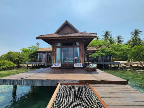 a small house on a dock in the water at Full Moon Island Resort in Kaoh Sdach