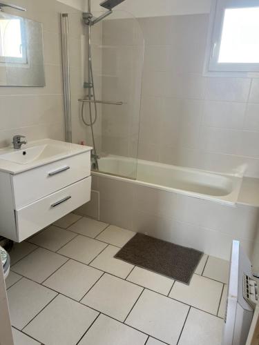 a white bathroom with a tub and a sink and a bath tub at La maison ensoleillée in Bérat