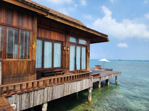 a house on a pier in the water at Full Moon Island Resort in Kaoh Sdach