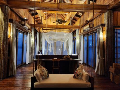 a bedroom with a bed in a room with windows at Full Moon Island Resort in Kaoh Sdach