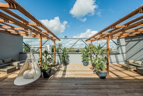 a balcony with potted plants and a hammock at Zaliakalnio Terasos apartamentai 2 in Kaunas