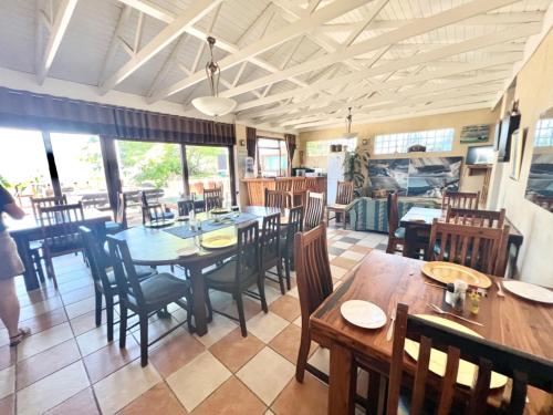 een eetkamer met houten tafels en stoelen bij Hoylake Inn in East London