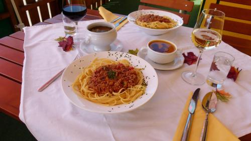 a table with a plate of pasta on a table at Landhotel SONNENHOF MotorradKrauk in Ulrichsberg