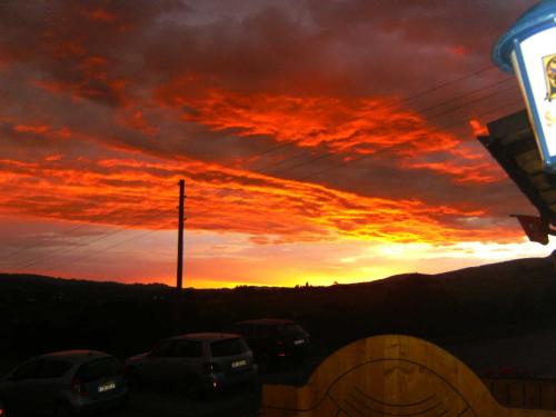 a sunset with cars parked in a parking lot at Landhotel SONNENHOF MotorradKrauk in Ulrichsberg