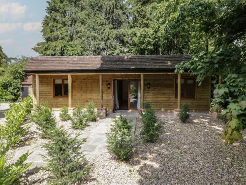 a small wooden cabin with a door in a yard at Yew Tree Cottage in Dartford