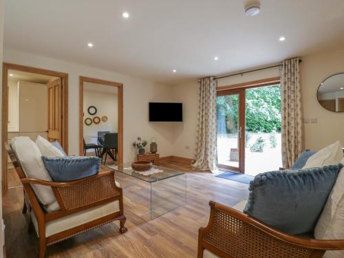 a living room with chairs and a glass table at Yew Tree Cottage in Dartford
