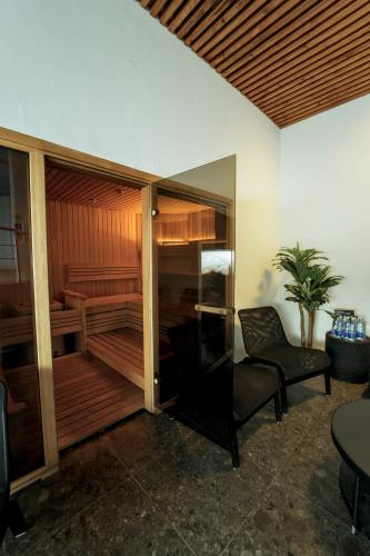 a room with a sauna with a chair and a table at Zaliakalnio Terasos apartamentai 2 in Kaunas