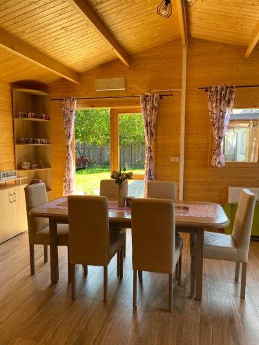 a dining room with a wooden table and chairs at Domek Letniskowy in Iława