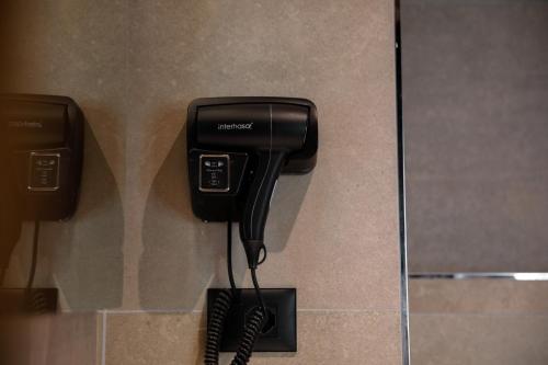 a phone hanging on a wall in a bathroom at Furra Hotel in Gjirokastër