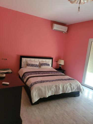 a bedroom with a bed with a red wall at APPARTEMENT Ras JEBEL6 in Raʼs al Jabal