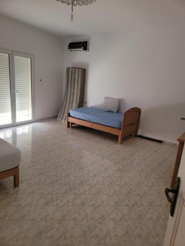 a bedroom with a bed in the corner of a room at APPARTEMENT Ras JEBEL6 in Raʼs al Jabal