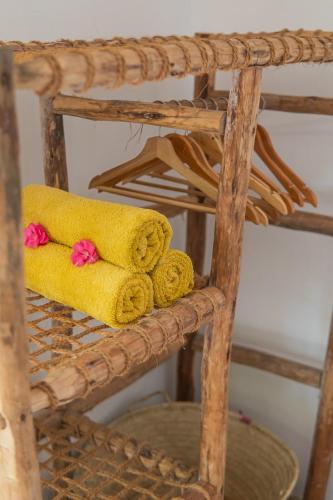 two towels on a wicker chair with pink flowers at Mr Kahawa in Paje