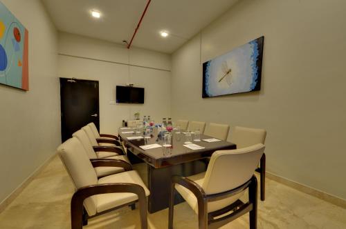 a dining room with a long table and chairs at The Fern Residency, Vadgaon - Talegaon, Pune in Pune