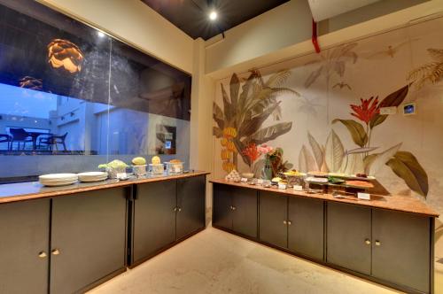 a kitchen with green cabinets and a large window at The Fern Residency, Vadgaon - Talegaon, Pune in Pune