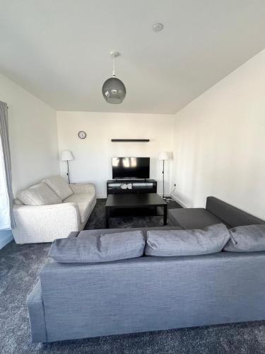 a living room with a couch and a piano at Beach side family rest and holiday in Llandudno