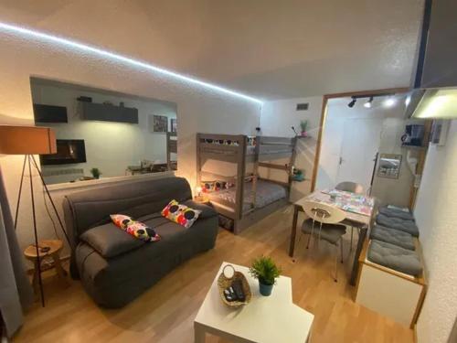 ein Wohnzimmer mit einer Couch und einem Etagenbett in der Unterkunft Studio chaleureux à Villarembert, 22 m², proche des pistes in Villarembert