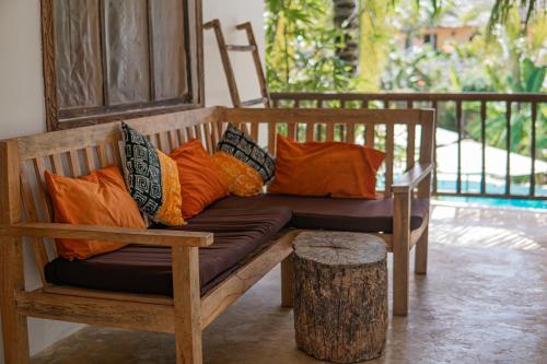 a bench with colorful pillows on a porch at Mr Kahawa in Paje