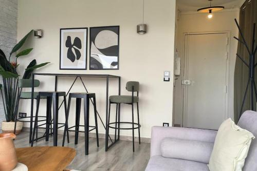 a living room with a table and stools at Appartement lumineux in Argenteuil
