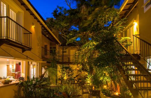 an outdoor patio with tables and chairs at night at La Chimère Buzios Essence in Búzios
