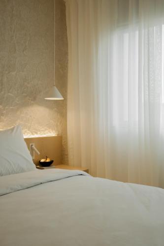 a bedroom with a white bed and a window at Hotel Hello Plovdiv - Free Parking and Pet Friendly in Plovdiv